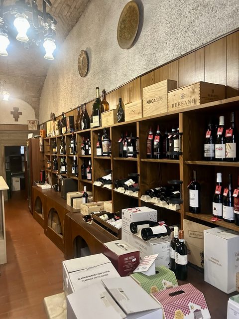 Gli scaffali di vini dell'Enoteca di Gubbio, sotto le volte in pietra