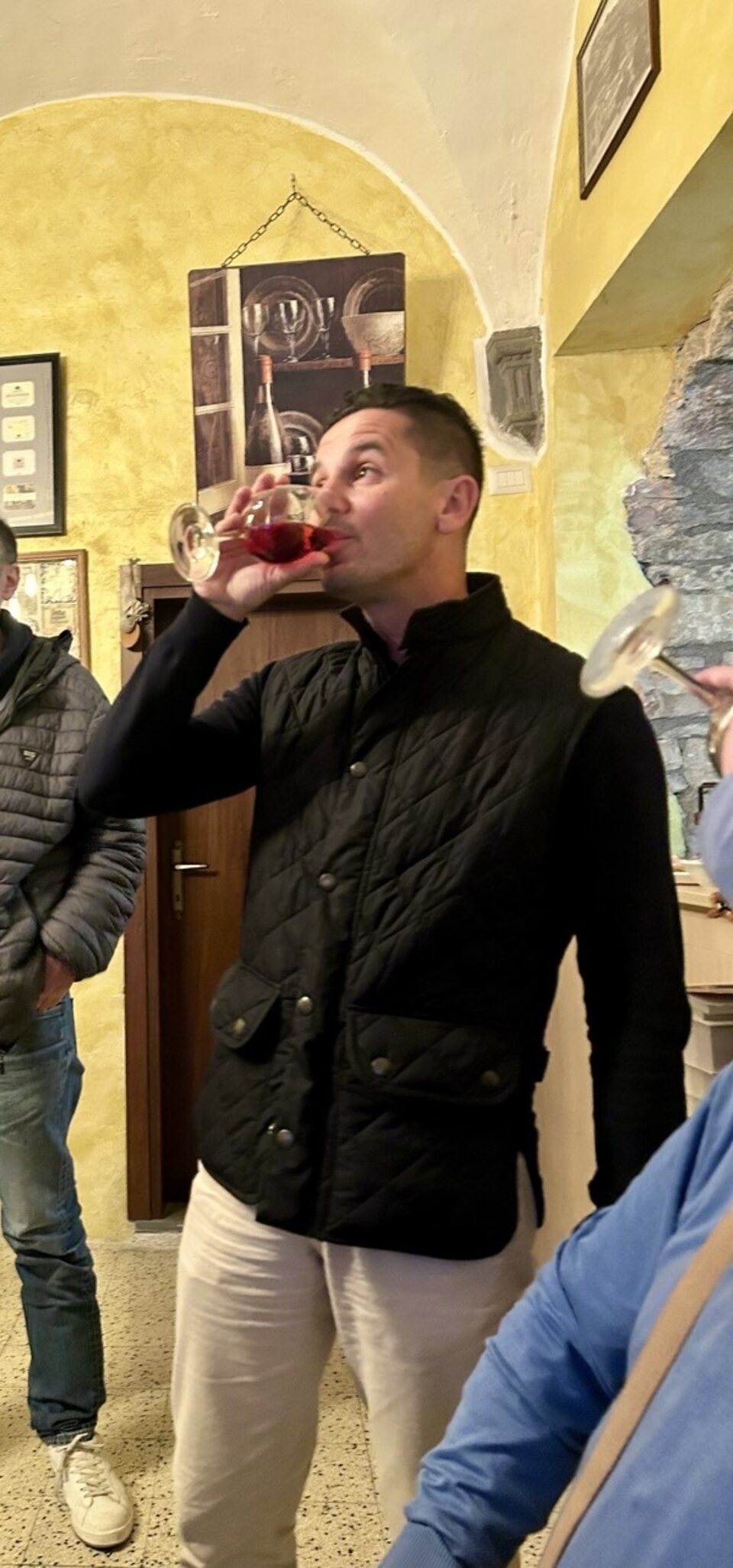Un cliente assapora un calice di vino rosso all'Enoteca di Gubbio